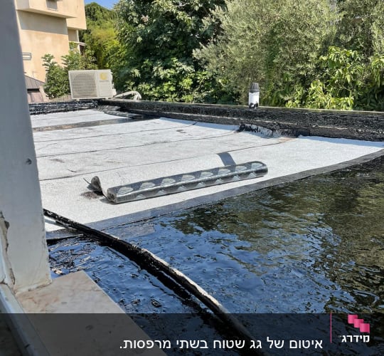 גג עם יריעות איטום וזפת שחורה